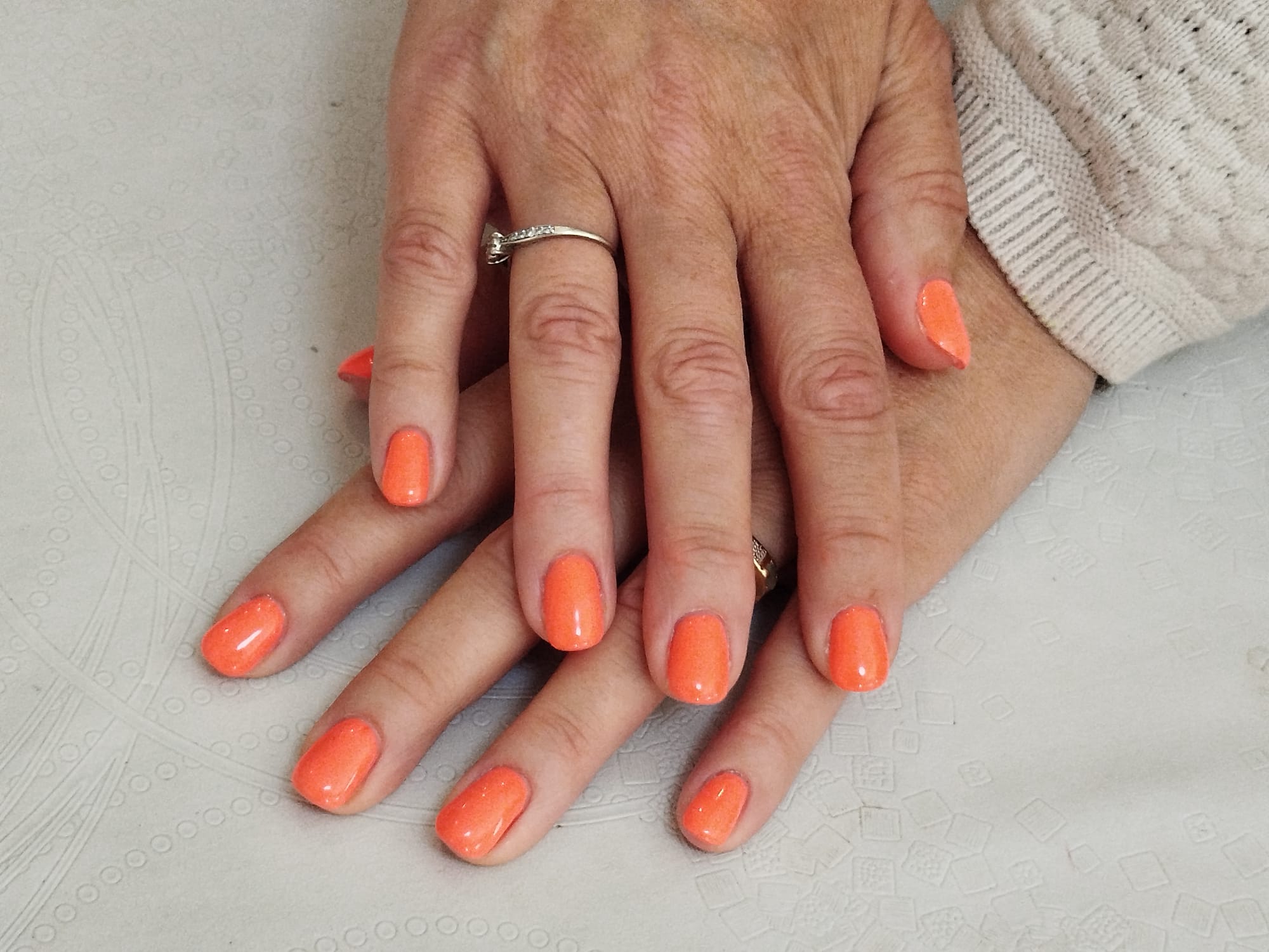 Manucure aux couleurs vives avec un vernis orange intense et ongles Squoval
