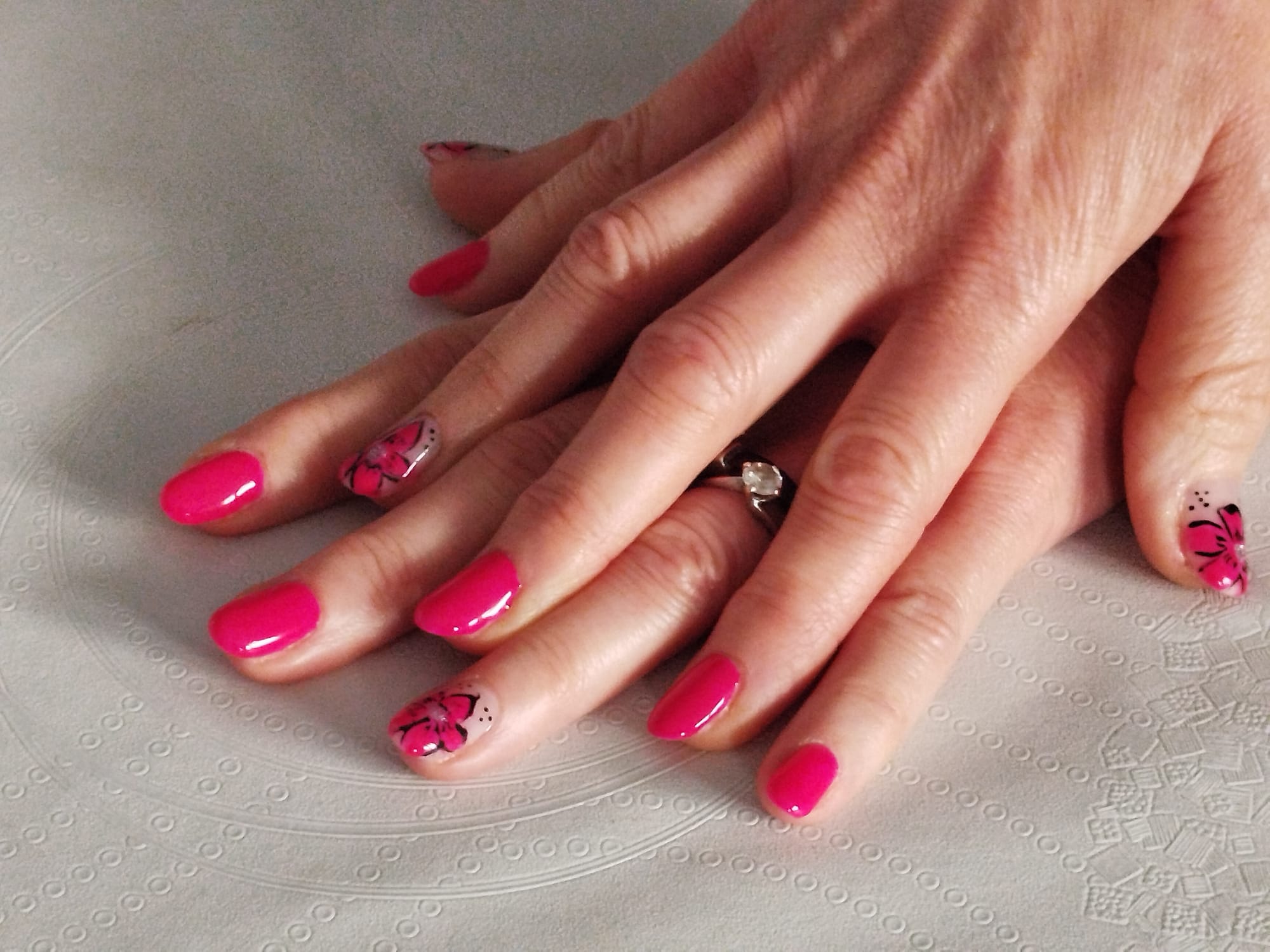 Ongles en gel rose vif avec nail art rose et noir assorti